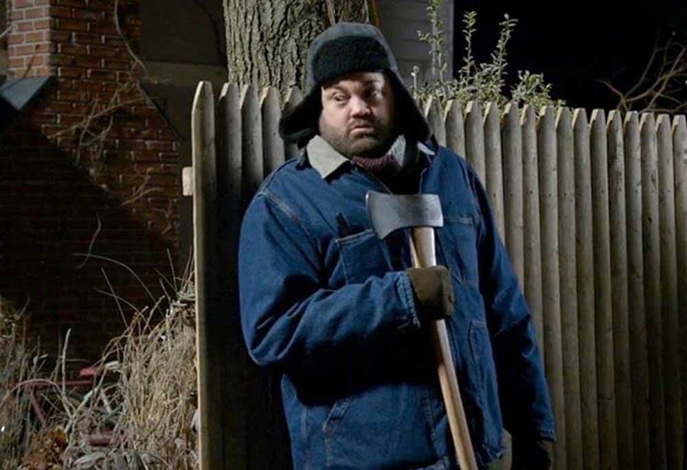 Chris Roach in Kevin Can Wait hiding with a hatchet